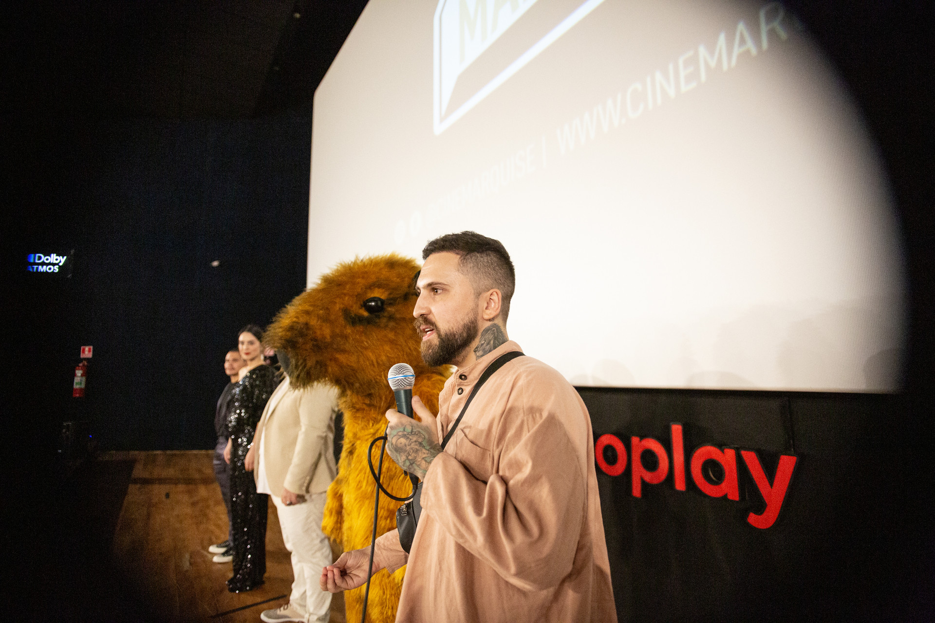 Lucas com mascote no palco do Cine Marquise - Dolby Cinema